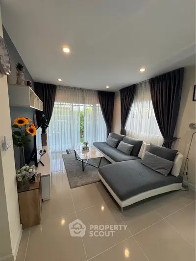 Modern living room with stylish decor and large windows for natural light.