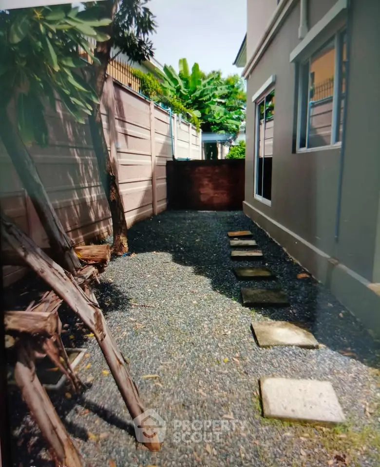 Charming garden pathway with stepping stones and lush greenery in a serene residential setting.