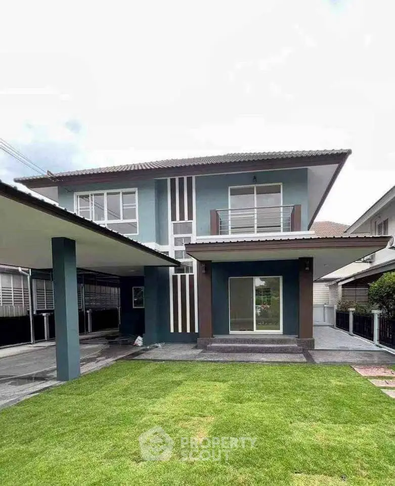 Modern two-story house with sleek design and spacious lawn, perfect for family living.