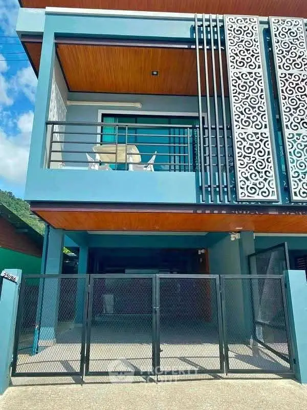 Modern two-story house with stylish balcony and gated entrance in a serene neighborhood.