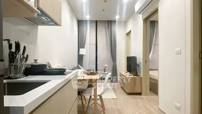 Modern open-layout kitchen and living room with sleek design and cozy ambiance.