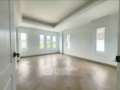 Spacious empty room with large windows and elegant flooring