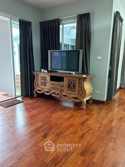 Spacious living room with elegant wooden TV stand and large windows