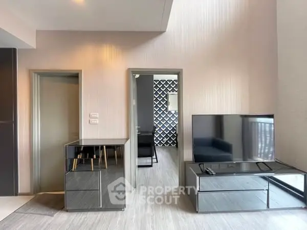 Modern living room with sleek furniture and flat-screen TV in stylish apartment.