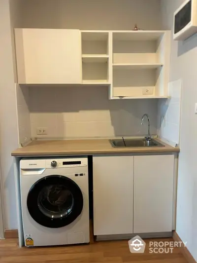 Compact kitchen with washing machine and modern cabinetry