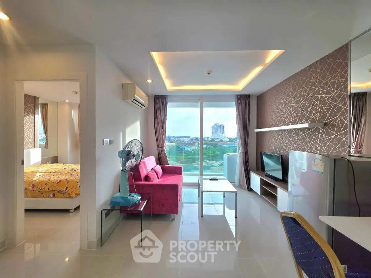 Modern living room with vibrant decor and city view, featuring a cozy sofa and sleek TV setup.