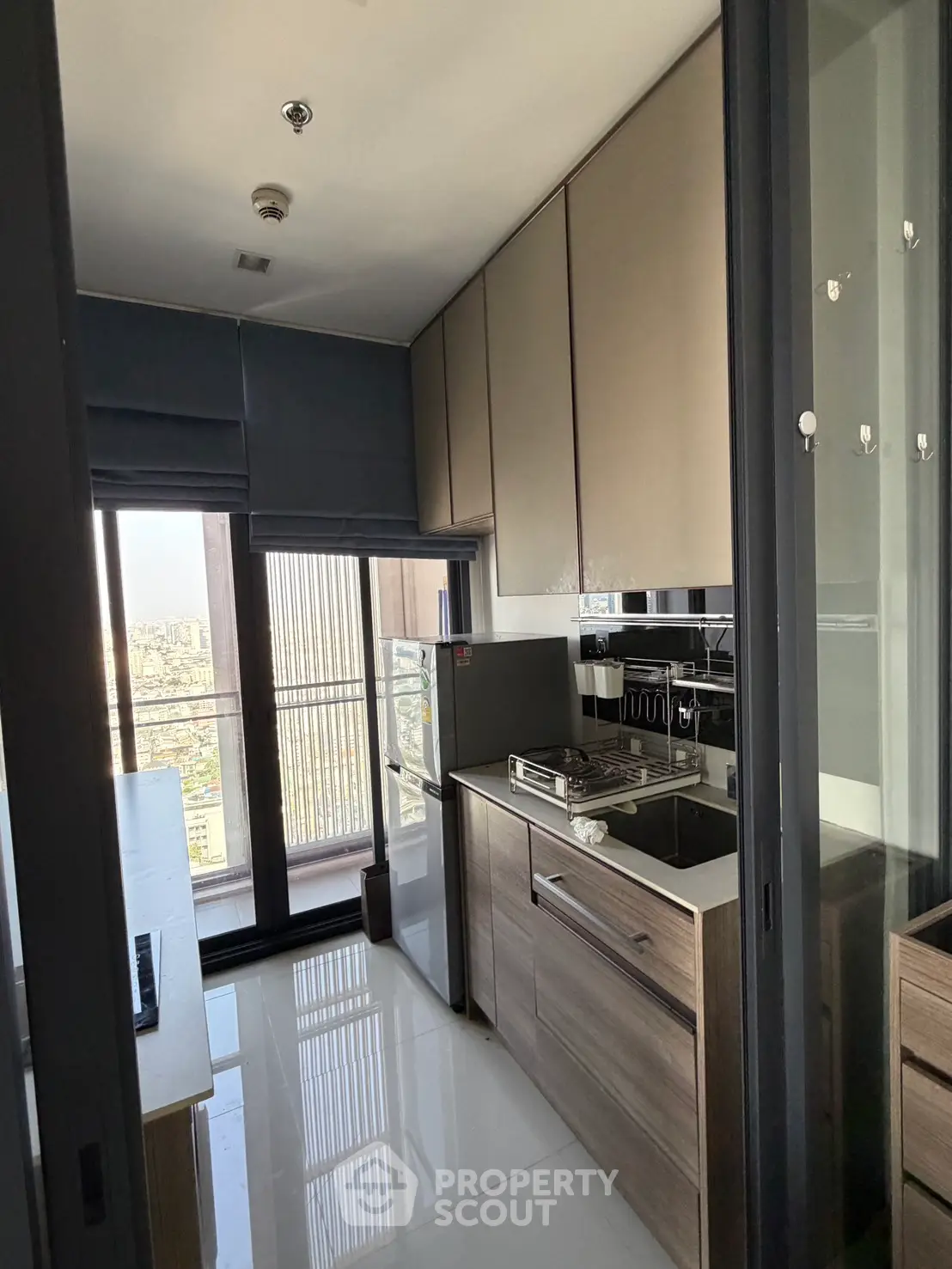 Modern kitchen with sleek cabinetry and city view from large windows