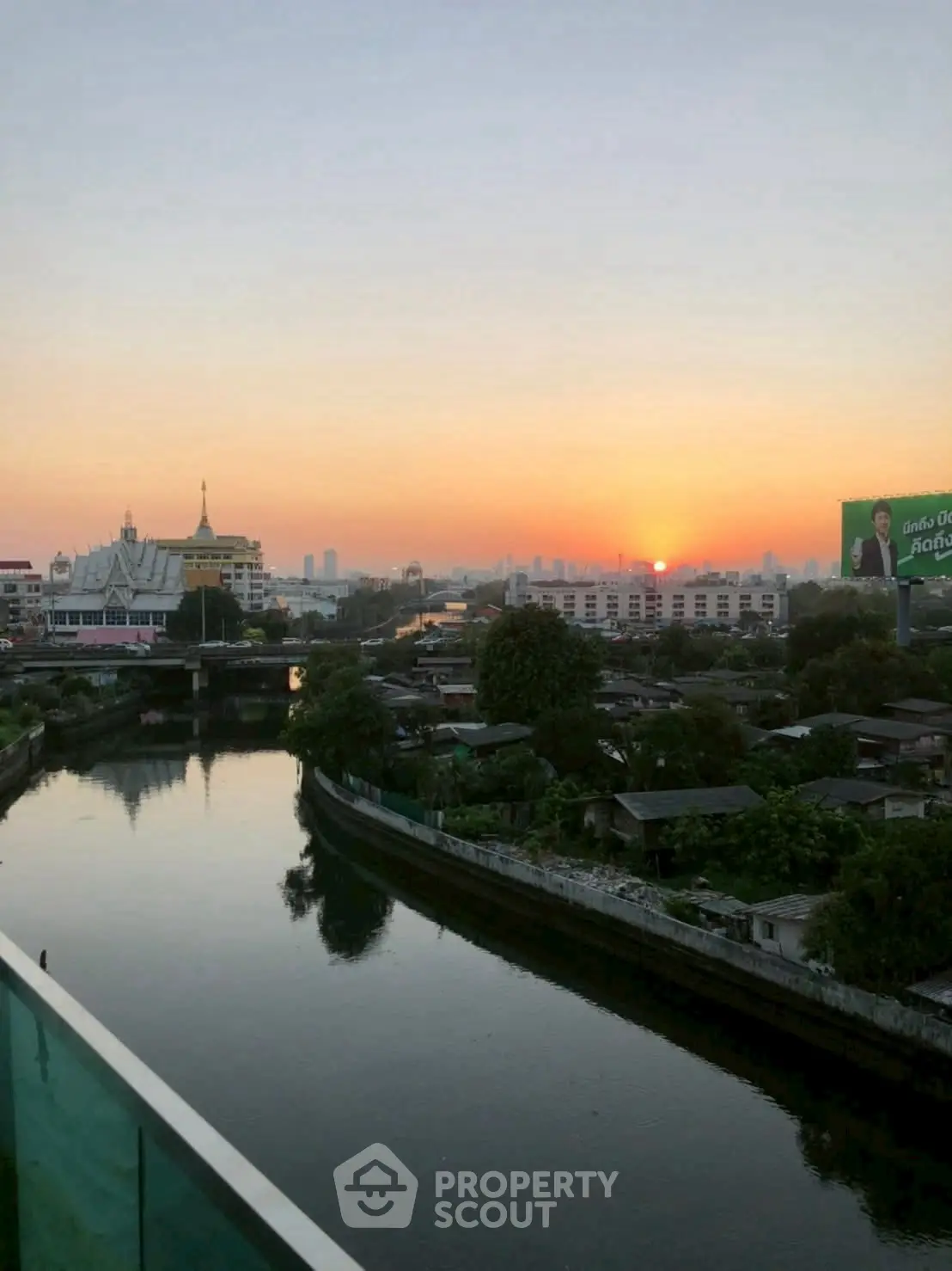 Stunning sunset view over a serene river and cityscape, perfect for tranquil living.