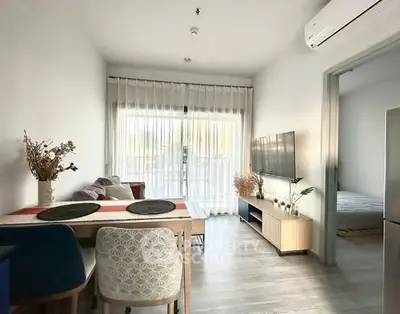 Modern living room with dining area, stylish decor, and natural light in a cozy apartment.