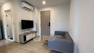 Modern living room with sleek furniture and mounted TV in a cozy apartment.