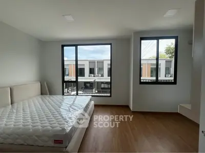 Spacious bedroom with large windows and modern design in a contemporary home.