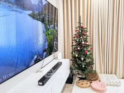 Cozy living room with Christmas tree and large TV, perfect for holiday gatherings.