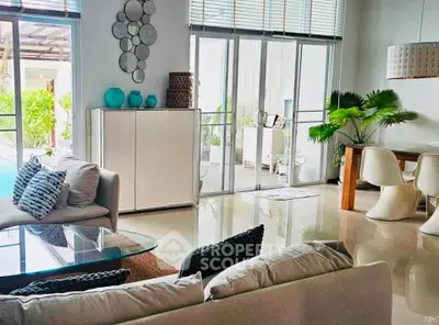 Luxurious living room with modern decor and poolside view, perfect for relaxation and entertaining.