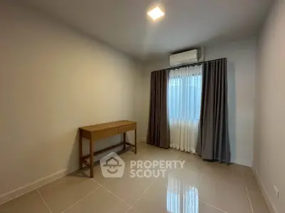 Spacious empty room with modern tile flooring and natural light