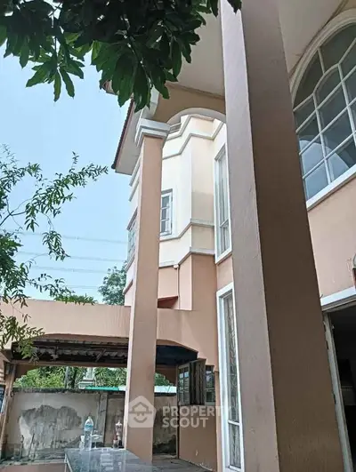 Elegant two-story house with large columns and arched windows, showcasing a spacious exterior design.