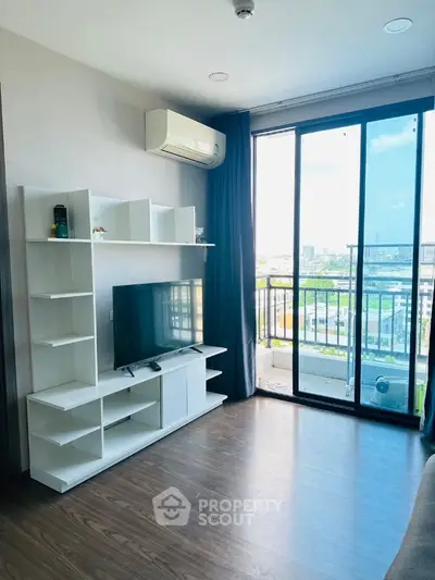 Modern living room with TV and balcony view in high-rise apartment