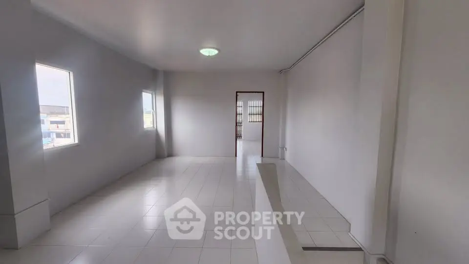 Spacious and bright interior with large windows and tiled flooring, ideal for customization.