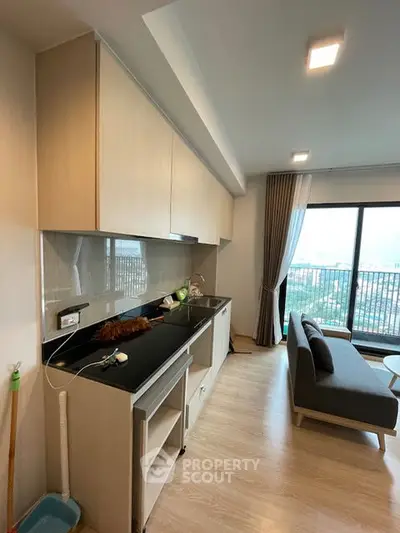 Modern open-layout kitchen and living room with large windows and city view.