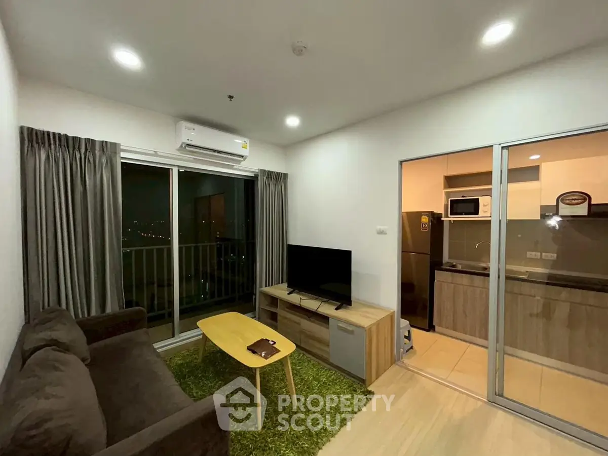 Modern living room with balcony view and open kitchen layout in a stylish apartment.