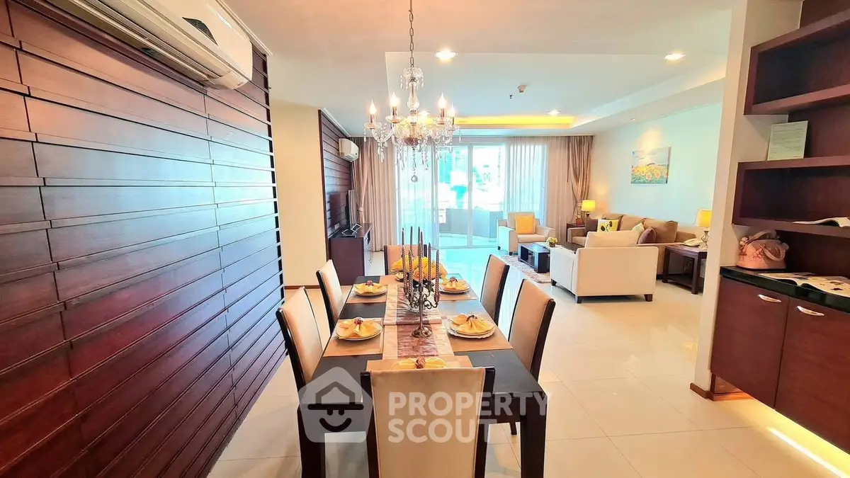 Spacious open-plan living and dining area with elegant chandelier and modern furnishings.