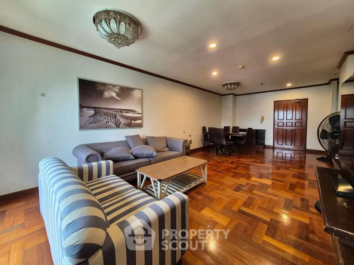 Spacious living room with elegant parquet flooring and stylish furniture in a modern apartment.