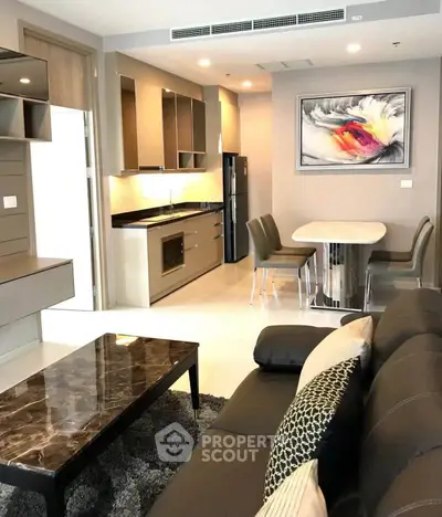 Modern open-layout living room with sleek kitchen and stylish dining area in a contemporary apartment.