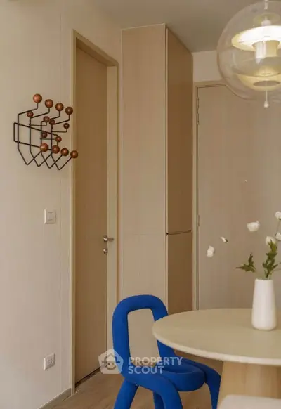 Modern interior with stylish decor and unique blue chair in a cozy dining area.