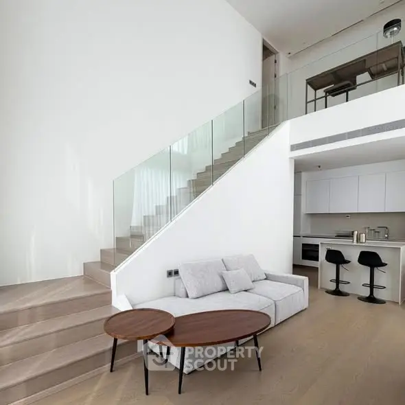 Modern duplex living room with sleek staircase and open kitchen layout