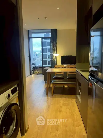 Modern apartment with open layout, featuring a cozy living area and city view balcony.