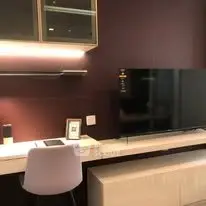 Modern living room with sleek TV setup and stylish desk area