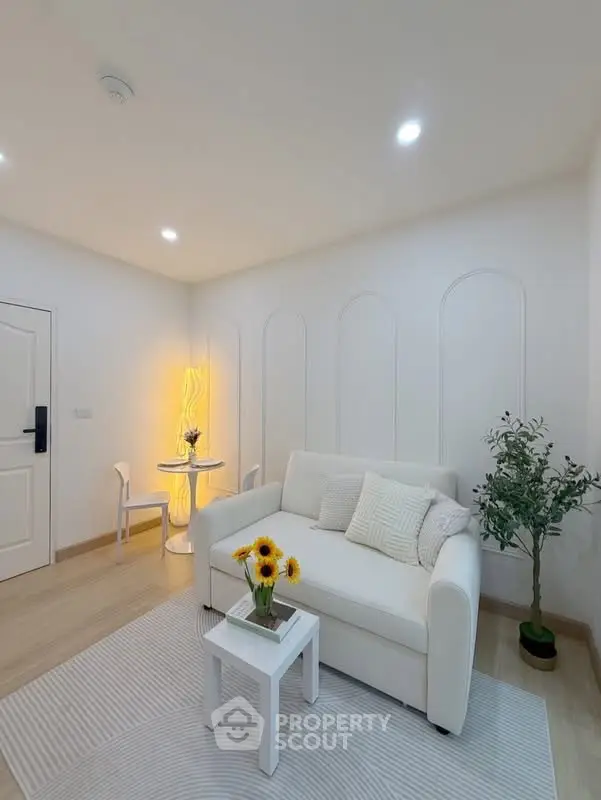 Charming living room with cozy white sofa, stylish decor, and warm lighting, perfect for relaxation.