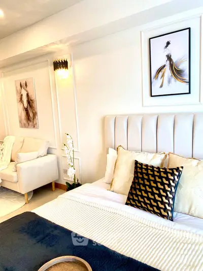 Luxurious bedroom with elegant decor and stylish artwork, featuring a plush bed and cozy seating area.