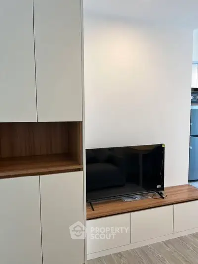 Modern living room with sleek cabinetry and flat-screen TV setup.