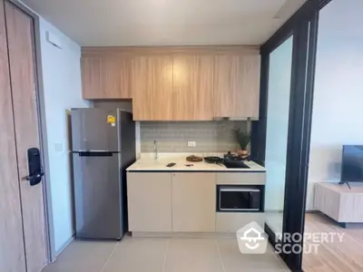 Modern compact kitchen with sleek cabinetry and appliances in a stylish apartment.