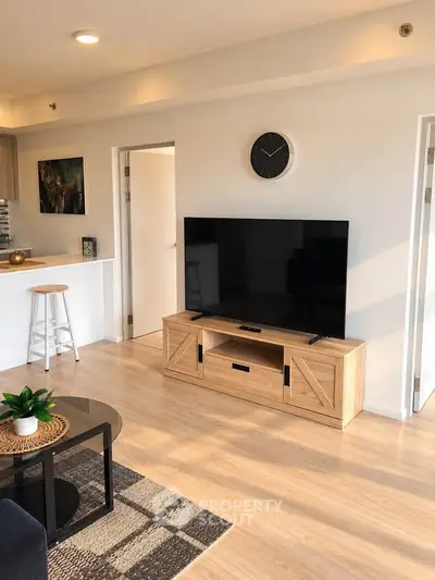 Modern living room with stylish decor, large TV, and open layout in a bright apartment.