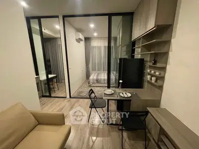 Modern studio apartment with glass partition, cozy living area, and stylish bedroom.