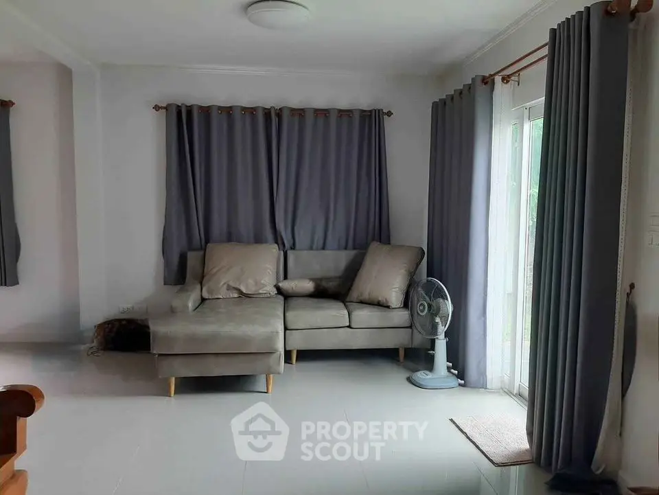 Spacious living room with modern gray sofa and large windows