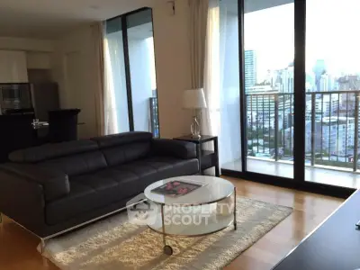 Modern living room with city view and stylish furniture in high-rise apartment.