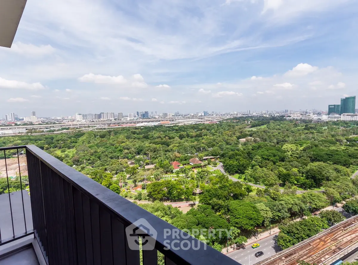 Stunning high-rise balcony view overlooking lush green park and city skyline.
