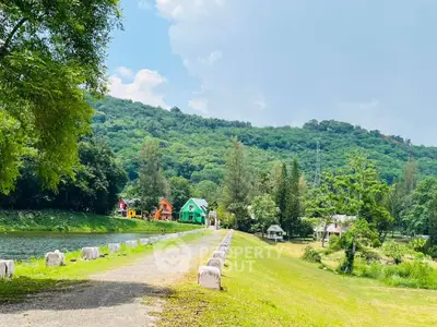 Scenic view of colorful houses by a lush green hillside and serene river.