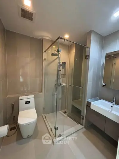 Modern bathroom with glass shower enclosure and sleek fixtures