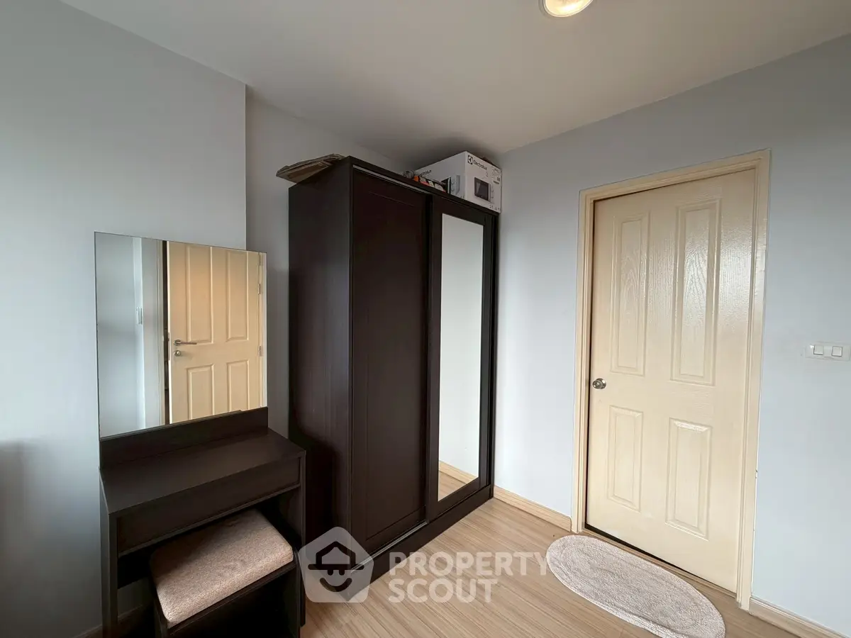 Cozy bedroom with wardrobe and vanity in modern apartment