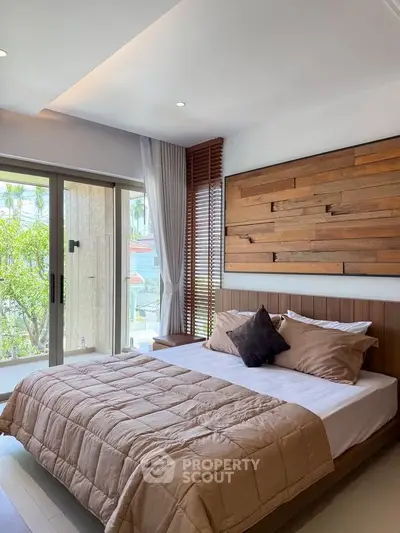 Luxurious bedroom with modern decor and large window overlooking greenery, featuring a stylish wooden accent wall.