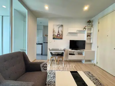 Modern living room with stylish decor and open layout, featuring a cozy seating area and a sleek entertainment unit.