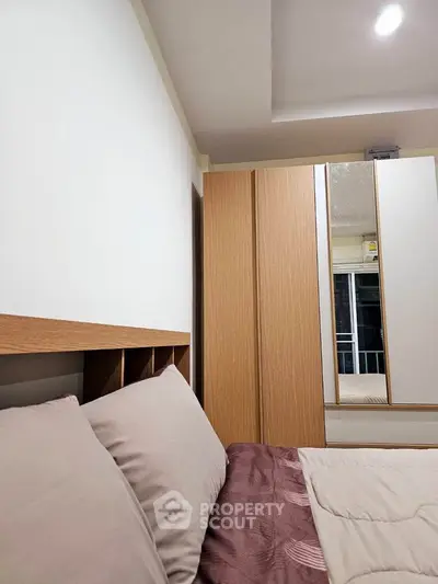 Modern bedroom with stylish wooden wardrobe and cozy bedding