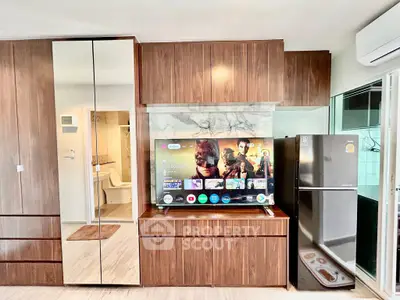 Modern living room with sleek wooden cabinetry and stainless steel fridge