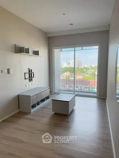 Modern living room with large window and minimalist furniture, offering a bright and airy atmosphere.