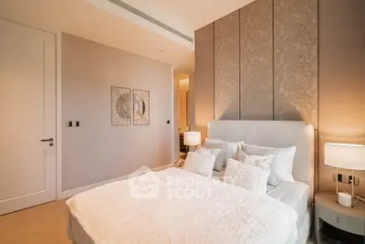 Luxurious bedroom with elegant decor and soft lighting, featuring a plush bed and stylish wall art.