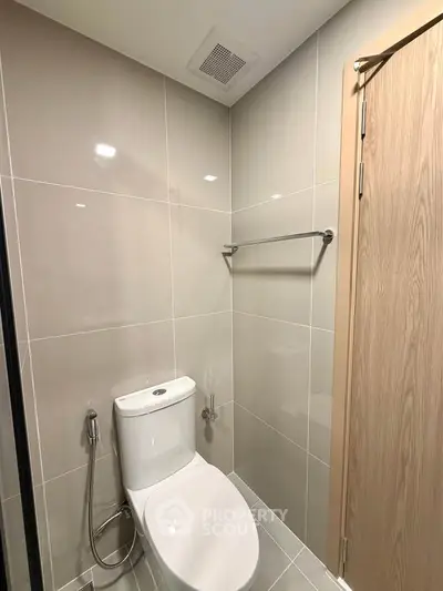 Modern bathroom with sleek tiles and contemporary fixtures in a stylish real estate property.