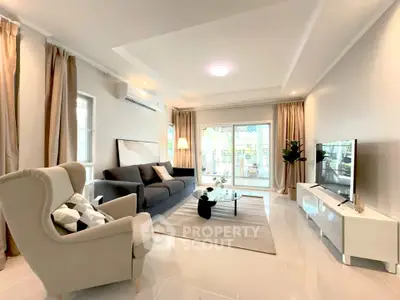 Spacious modern living room with elegant decor and natural light, featuring a cozy seating area and stylish furnishings.